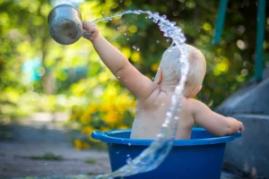 baby sitting in a bowl throwing water